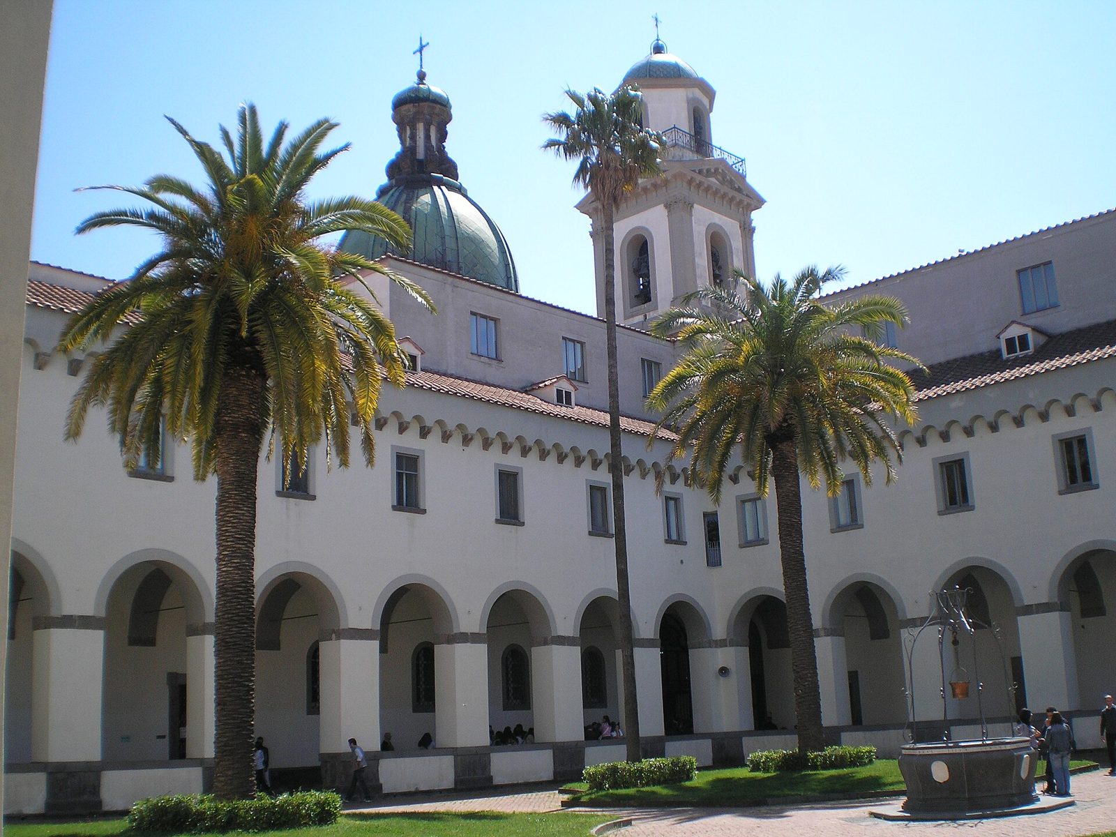 Chiostro del santuario della Madonna dell'Arco a Sant'Anastasia con palme, pozzo, cupola verde e campanile